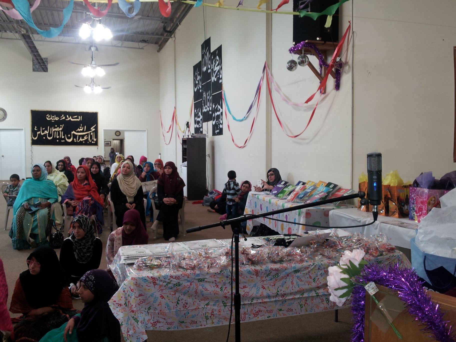 Academy gathering with families, books and gifts on display