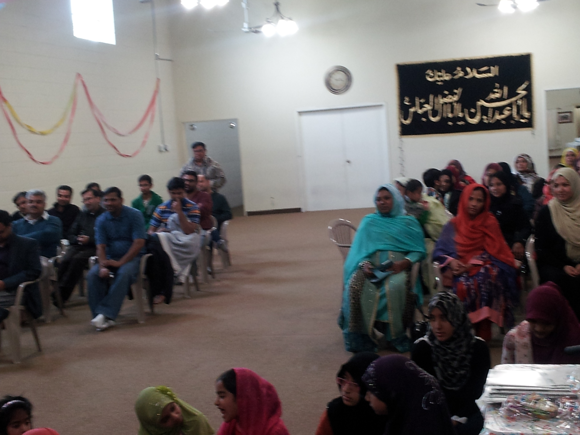 Adults and children seated together in the academy hall