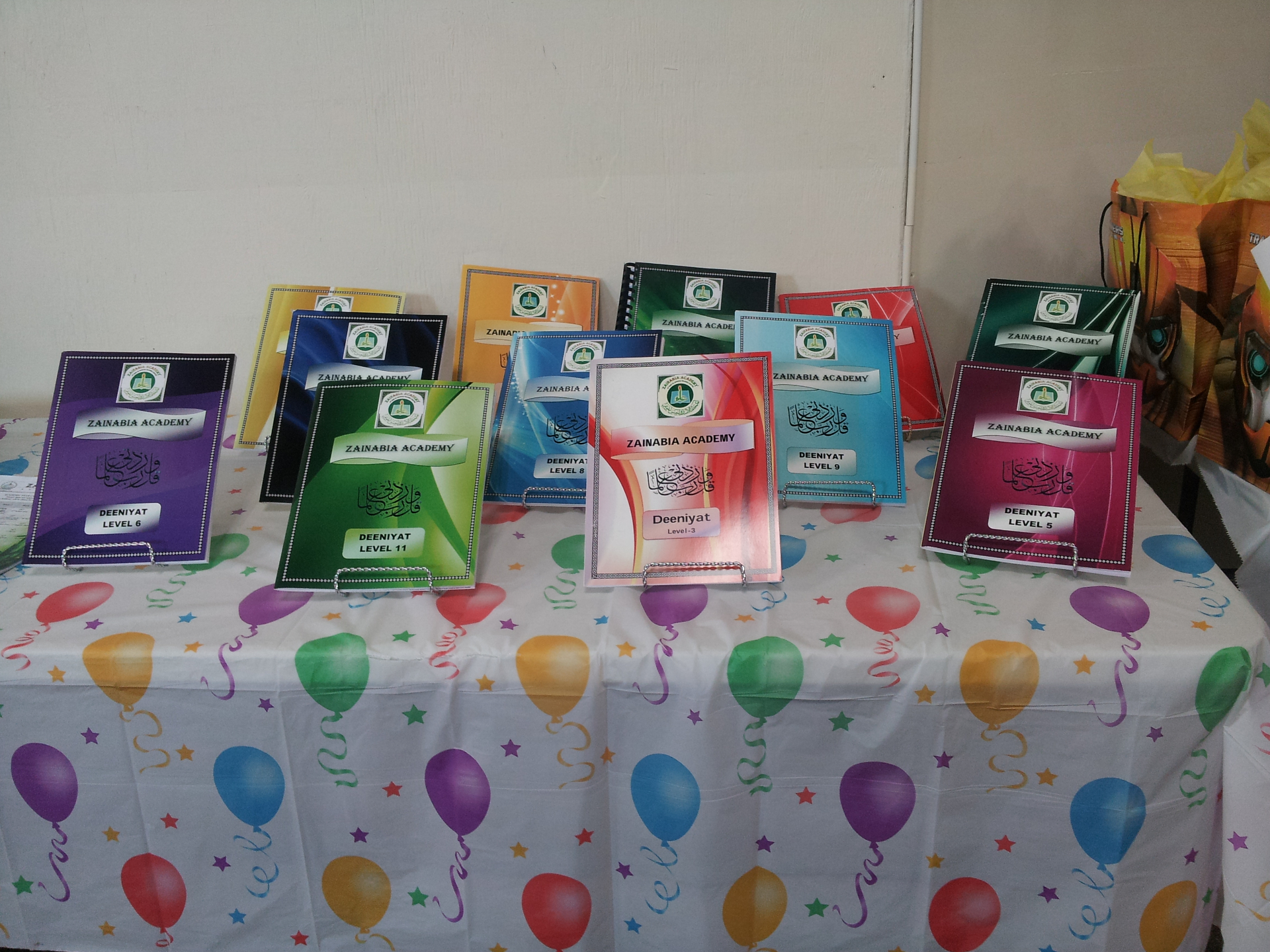 Deeniyat books displayed at an academy celebration